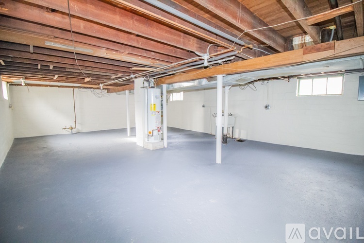 A spacious room with a high ceiling and exposed wooden beams.