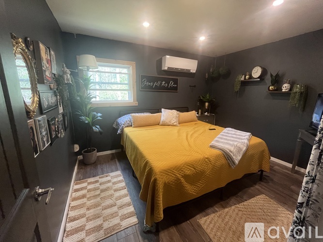A bedroom with a yellow bed and a mirror on the wall.