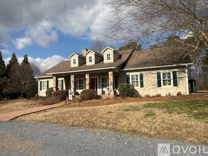 A two-story house with a front porch and a driveway.
