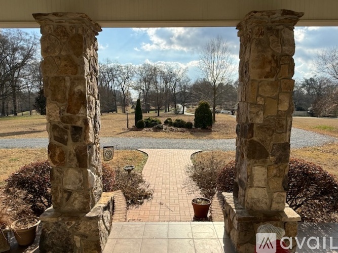 A stone pillar stands in front of a brick walkway.