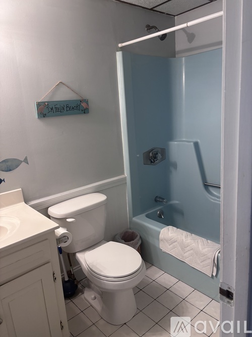 A bathroom with a toilet, sink, and a shower stall.