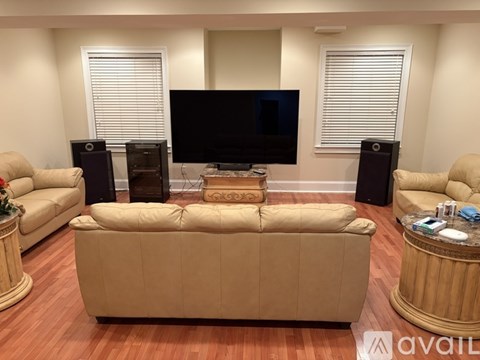 A living room with a beige sofa, a television, and two speakers.