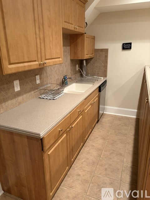A kitchen with wooden cabinets and a tiled backsplash.