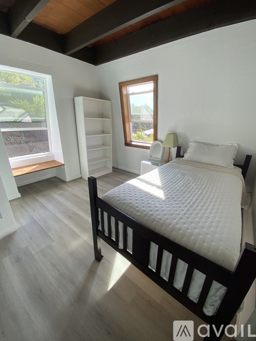 A bedroom with a large bed and a window.