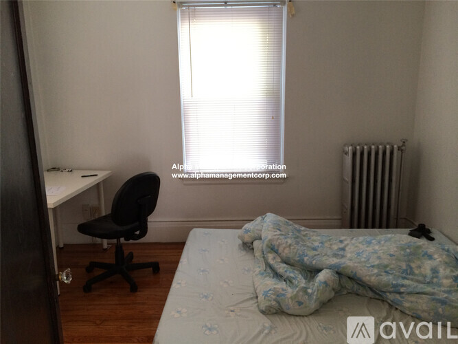 A bedroom with a bed, desk, and chair.