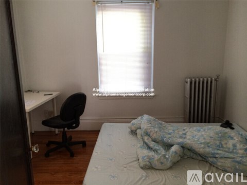 A bedroom with a bed, desk, and chair.