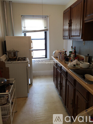 A kitchen with a white fridge and wooden cabinets.