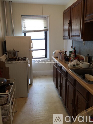 A kitchen with a white fridge and wooden cabinets.