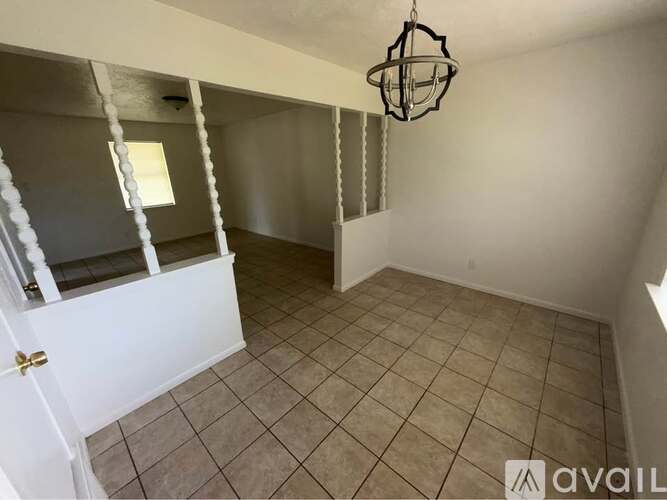 A room with a white door and a hanging light fixture.