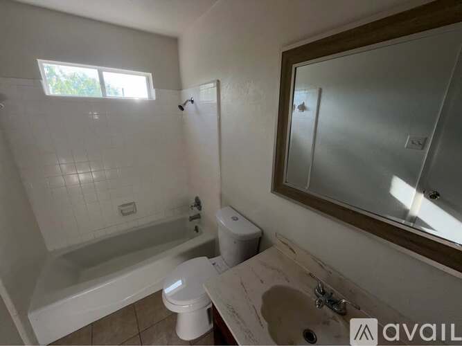 A bathroom with a toilet, sink, and bathtub.