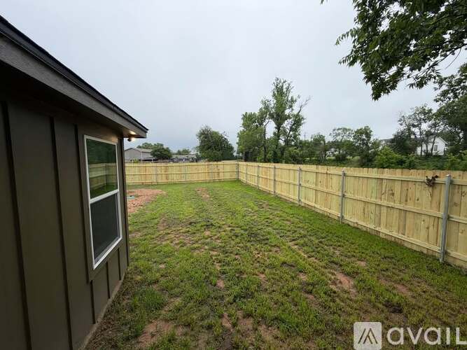 A backyard with a wooden fence and a shed.