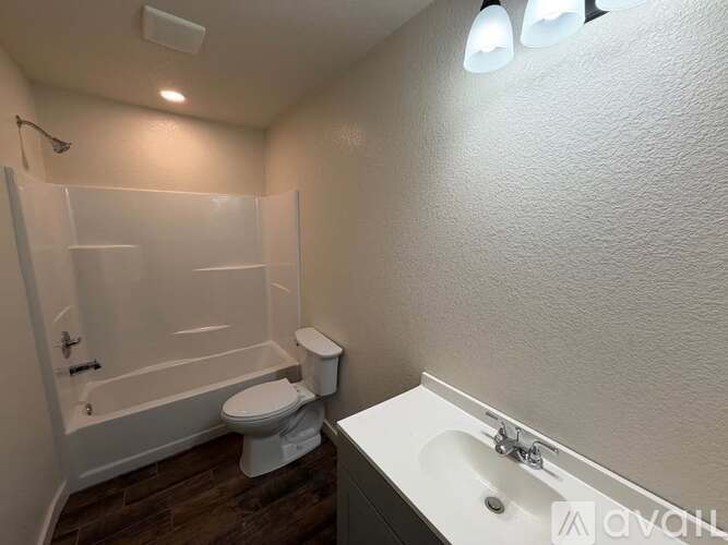 A small bathroom with a toilet, sink, and bathtub.