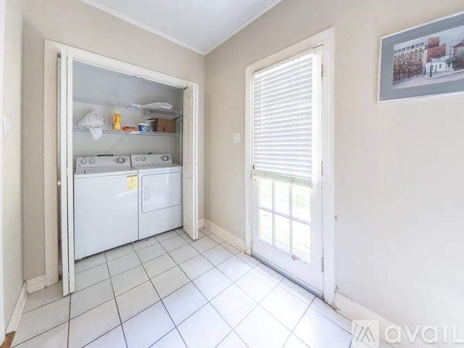 A small kitchen with a white fridge and a white door.