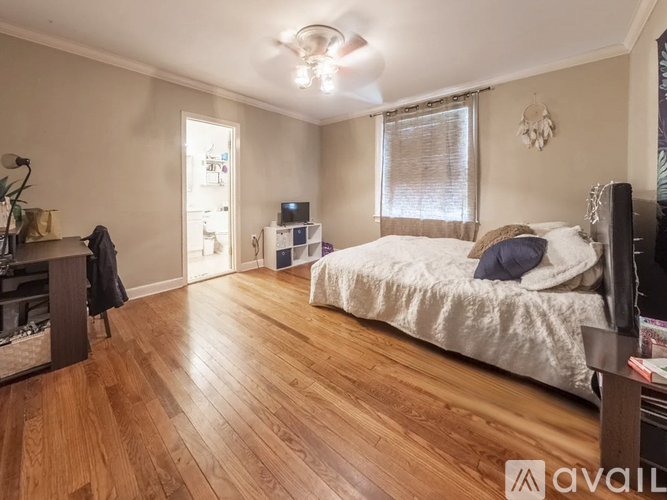 A bedroom with a bed, a dresser, and a ceiling fan.