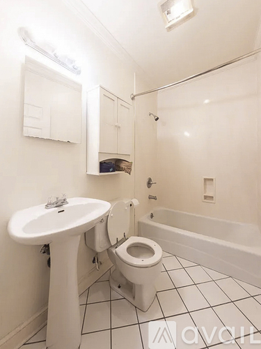 A white bathroom with a sink, toilet and bathtub.