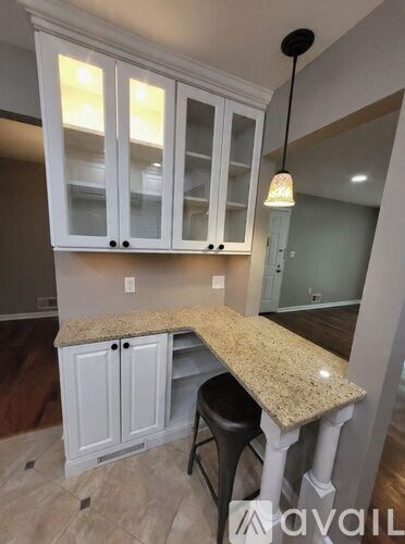 A kitchen with white cabinets and a granite countertop.