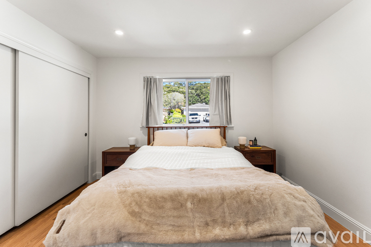 A bedroom with a large bed and a window overlooking a street.