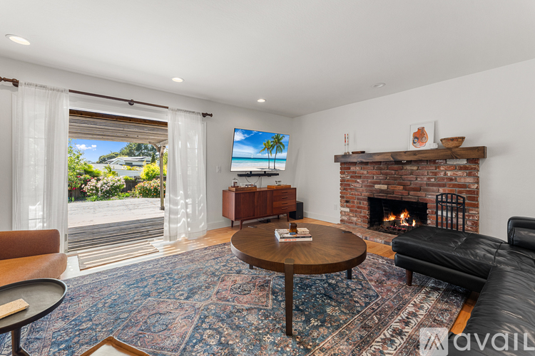 A living room with a fireplace and a flat screen TV.