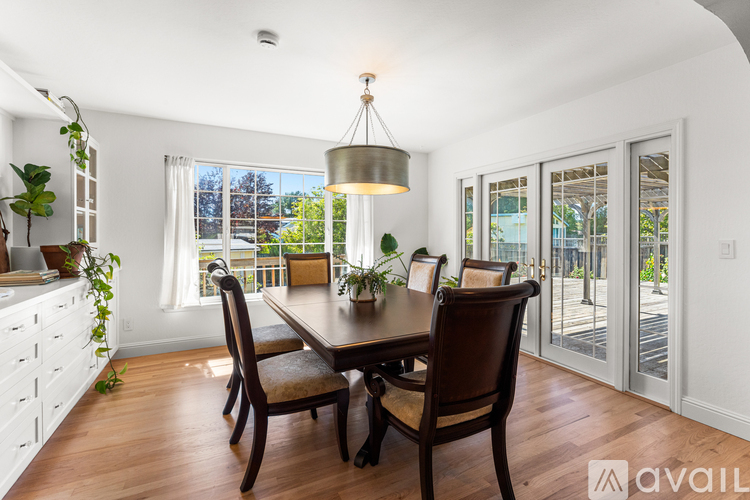 A dining room with a wooden table and chairs.