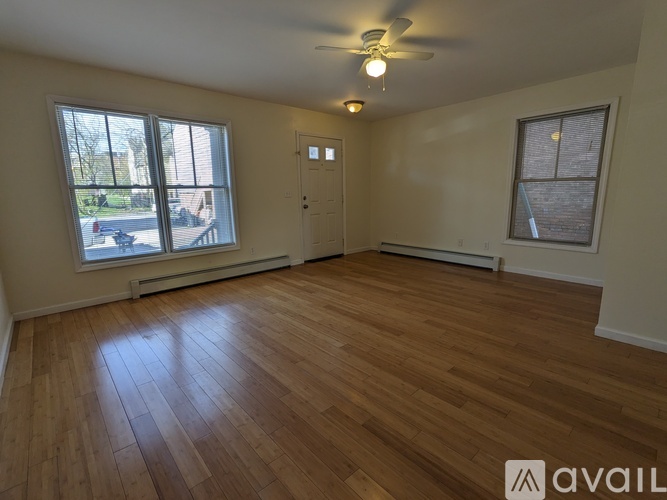 A room with wooden flooring and a ceiling fan.
