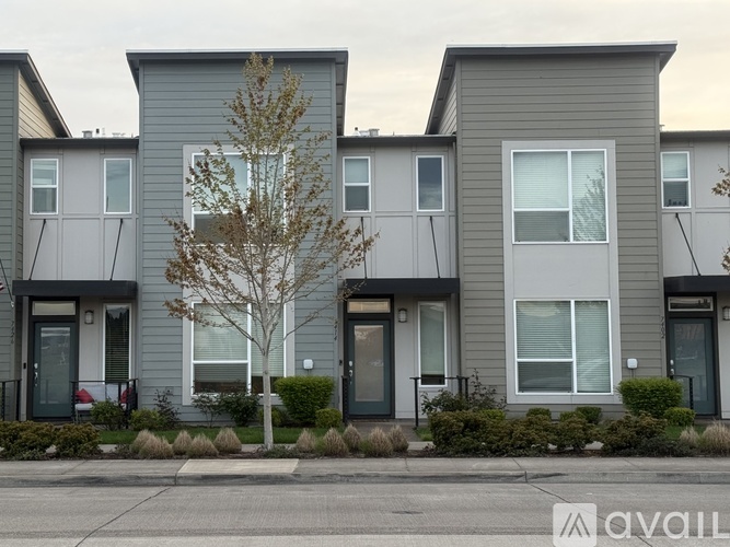 A row of modern houses with grey exteriors and white windows.