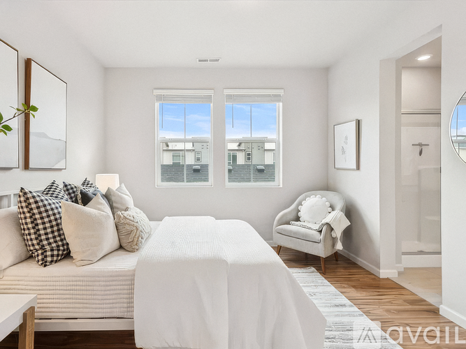 A bedroom with a large bed and a chair by the window.