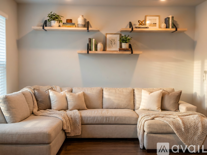 A living room with a large couch and shelves above it.
