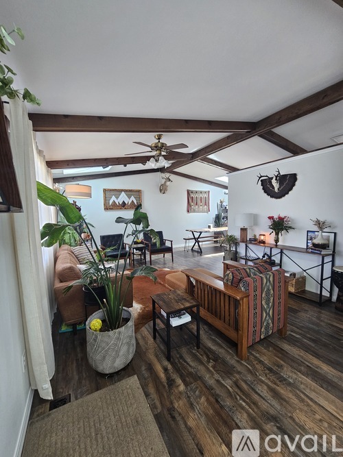 A living room with a wooden floor and a ceiling fan.