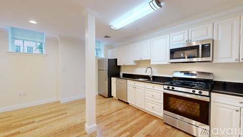 A kitchen with white cabinets and a black stove top.