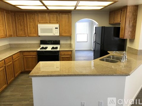 A kitchen with wooden cabinets and a granite countertop.