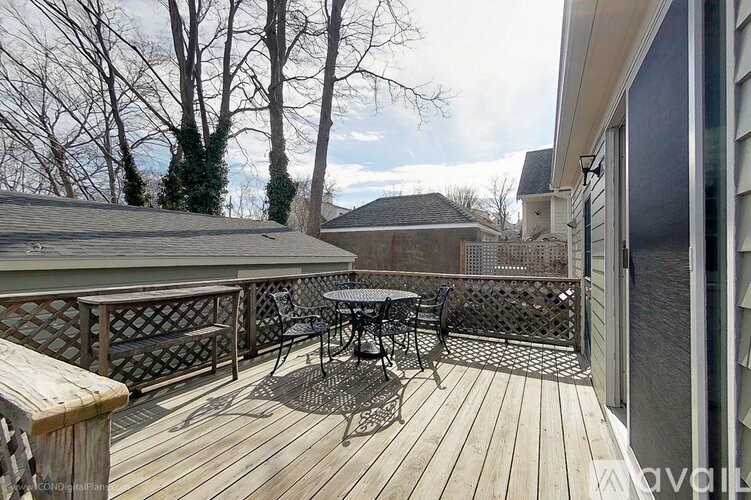 A wooden deck with a table and chairs is surrounded by trees.