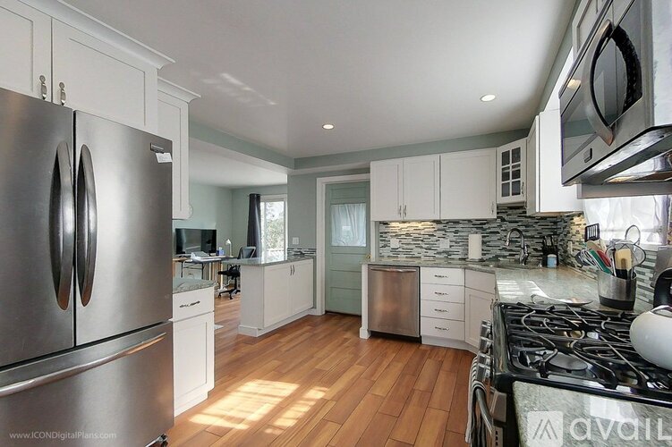 A kitchen with a stainless steel refrigerator and a stove top oven.