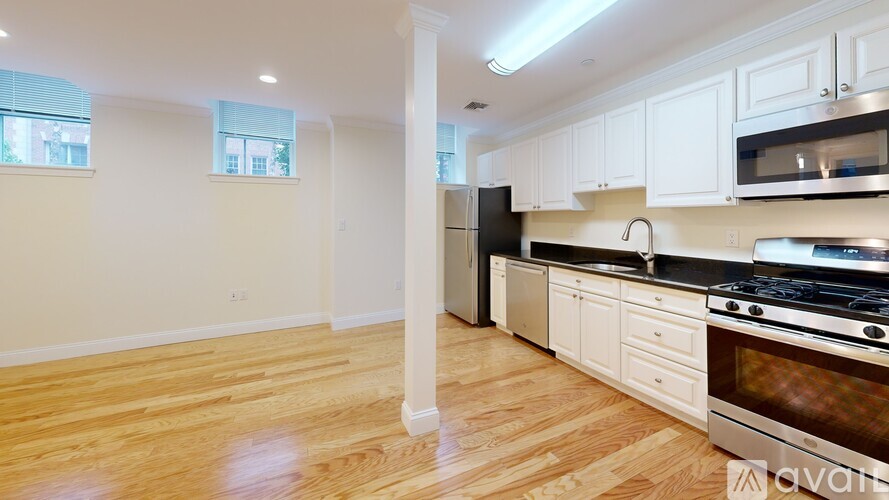 A kitchen with white cabinets and a black stove top oven.