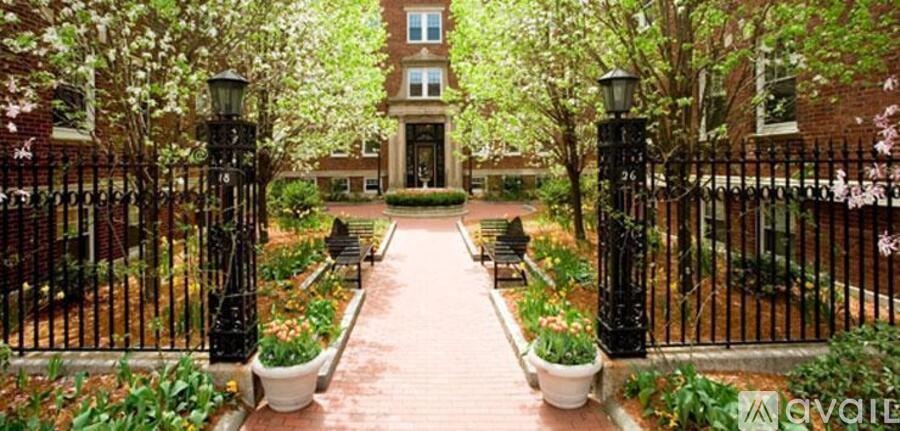 A black iron gate leads to a brick building.