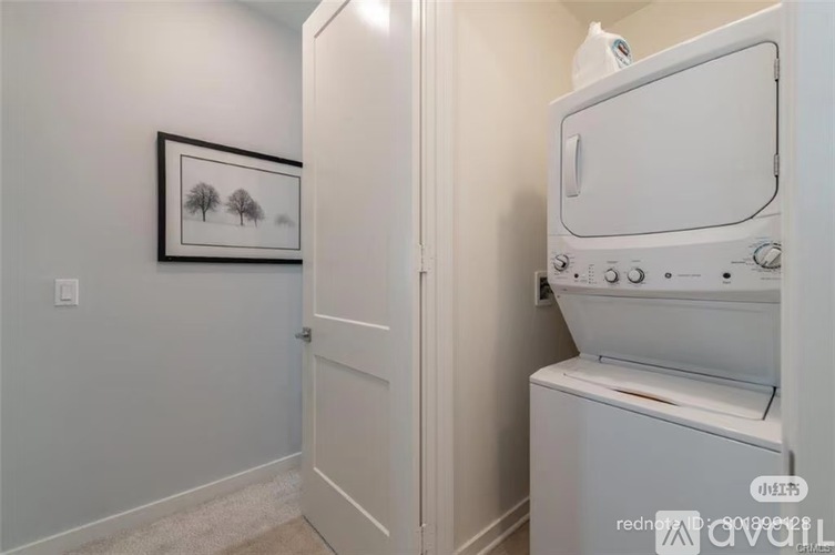 A white washing machine is in a small laundry room.