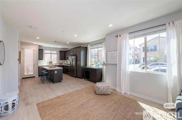 A well-lit, spacious kitchen and living room with a dining table and chairs.
