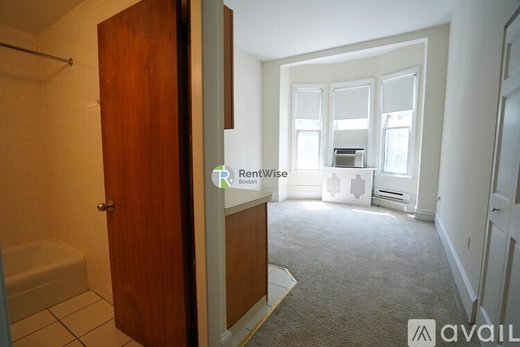 A room with a carpeted floor and a wooden door.