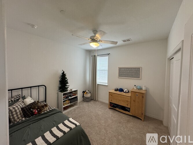 A bedroom with a bed, a dresser, and a ceiling fan.