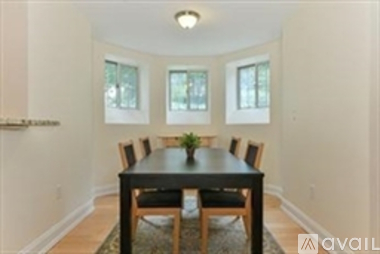 A dining room with a table and chairs.