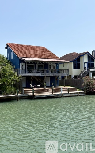 A house with a red roof is situated on the water.