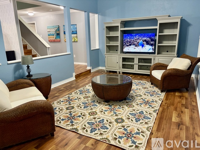 A living room with a television, a chair, and a table.