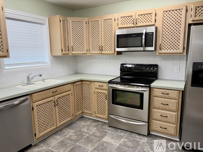 A kitchen with wooden cabinets and a black stove top oven.