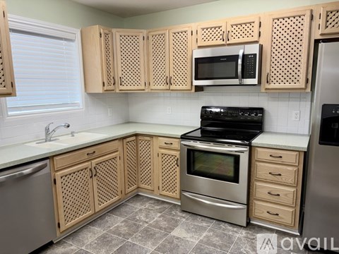 A kitchen with wooden cabinets and a black stove top oven.