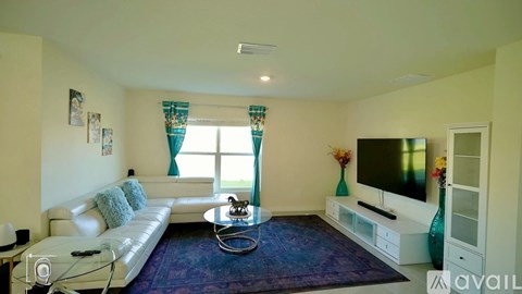 A living room with a white couch and a television.