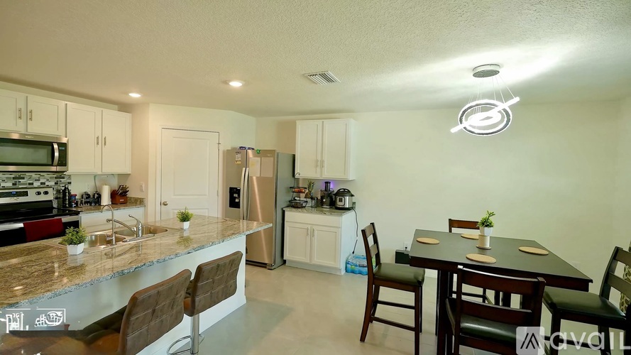 A kitchen with a dining table and chairs.