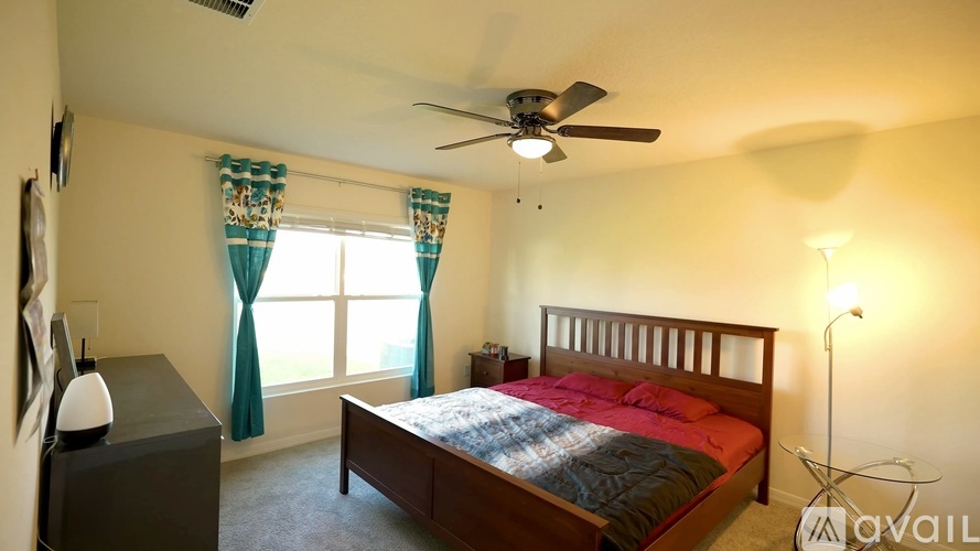 A bedroom with a bed, nightstand, and window.