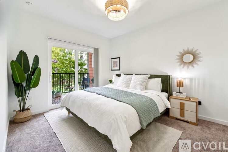 A bedroom with a large bed and a potted plant.