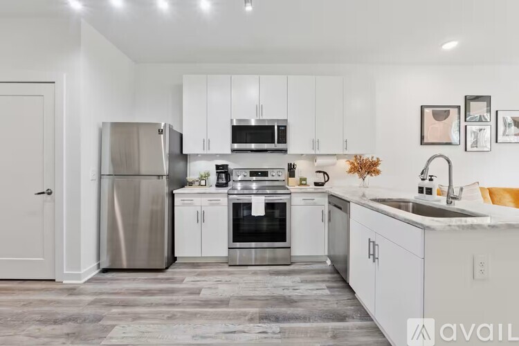 A modern kitchen with stainless steel appliances and white cabinets.