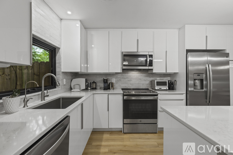 A modern kitchen with white cabinets and stainless steel appliances.