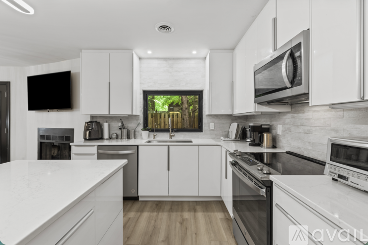 A modern kitchen with white cabinets and stainless steel appliances.